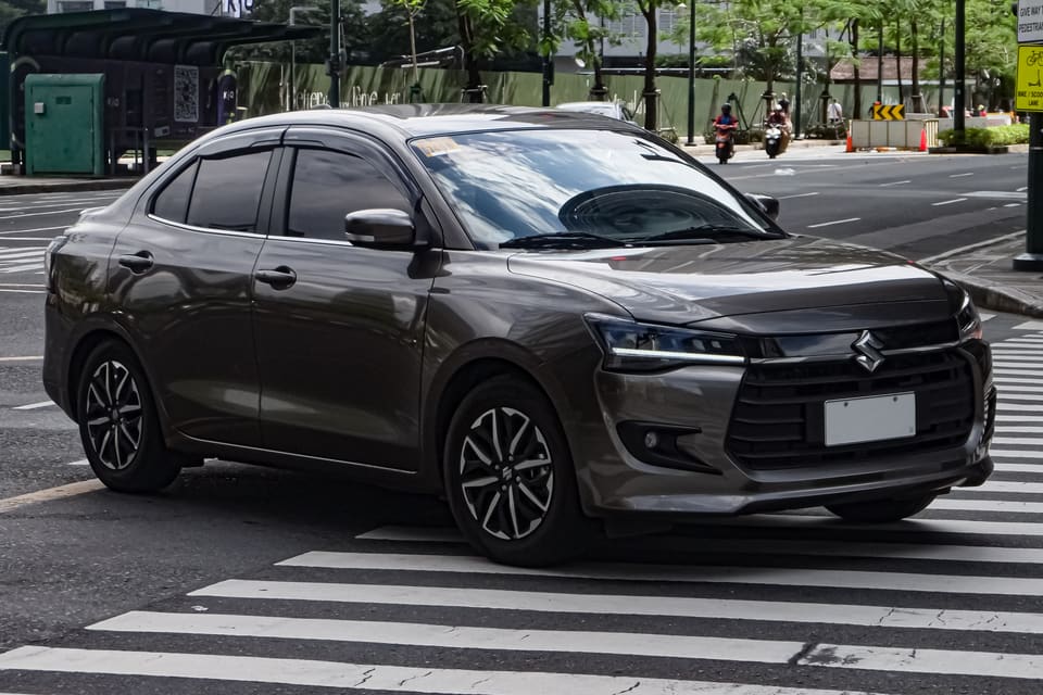 Suzuki Dzire grise de nouvelle génération engagée sur un passage piéton en ville